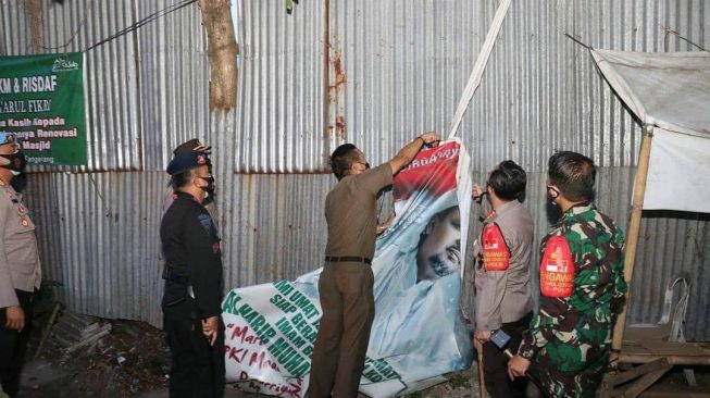 Personel gabungan TNI, Polri, dan Satpol PP Kabupaten Tangerang mencopot atribut FPI setelah pemerintah mengeluarkan keputusan pembubaran ormas pimpinan Habib Rizieq Shihab tersebut, Rabu (30/12/2020). [Instagram@polreskotatangerang]