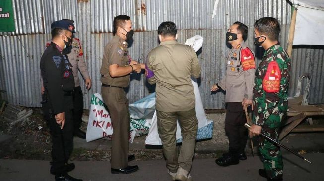 Personel gabungan TNI, Polri, dan Satpol PP Kabupaten Tangerang mencopot atribut FPI setelah pemerintah mengeluarkan keputusan pembubaran ormas pimpinan Habib Rizieq Shihab tersebut, Rabu (30/12/2020). [Instagram@polreskotatangerang]