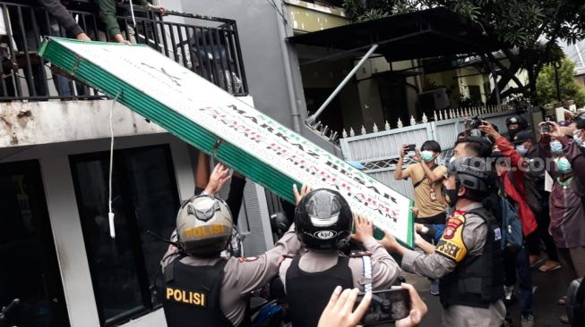 Brimob membongkar atribut FPI di Petamburan, Jakarta, Rabu (30/12). [Suara.com/Novian Ardiansyah]