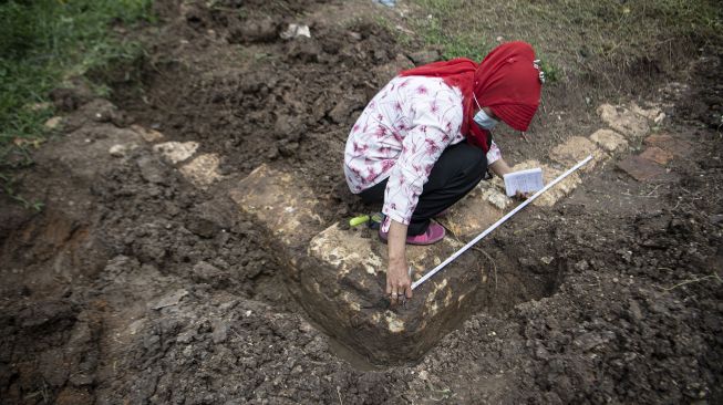 Arkeolog dari Balai Arkeologi Sumatera Selatan mengukur jejeran batu kapur yang ditemukan di kawasan Ilir Timur (IT) II, Palembang, Sumatera Selatan, Rabu (30/12/2020).   [ANTARA FOTO/Nova Wahyudi]