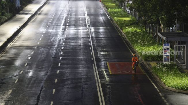 Warga bersepeda saat diberlakukannya Car Free Night (malam bebas kendaraan) dan Crowd Free Night (malam bebas keramaian) pada malam pergantian tahun di Jalan Sudirman, Jakarta, Kamis (31/12/2020). [Suara.com/Angga Budhiyanto]