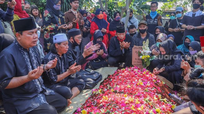 Keluarga dan kerabat berdoa diatas pusara Komedian Omaswati di TPU Cisalak, Cimanggis, Depok, Jawa Barat, Jumat (17/7/2020).  [Suara.com/Alfian Winanto]