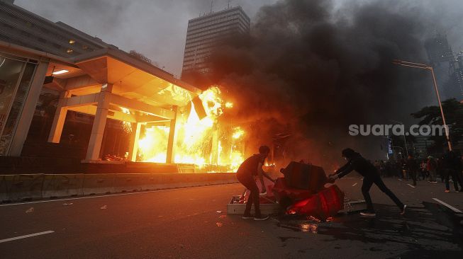 Pengunjuk rasa yang menolak pengesahan Undang-Undang Cipta Kerja membakar Halte Transjakarta Bundaran HI, Jakarta, Kamis (8/10/2020). [Suara.com/Angga Budhiyanto]