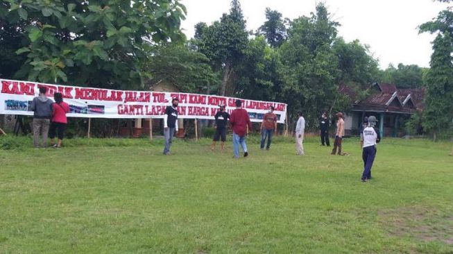 Warga di kebayanan III Desa Tambakan, Kecamatan Jogonalan, memasang spanduk minta lahan pengganti lapangan sepak bola di daerah setempat, Rabu (30/12/2020). Lapangan sepak bola di kebayanan III bakal terdampak jalan tol Solo-Jogja. (Solopos.com/Ponco Suseno)