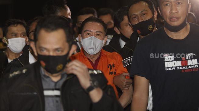 Petugas kepolisian membawa buronan kasus korupsi pengalihan hak tagih (cessie) Bank Bali Joko Soegiarto Tjandra alias Djoko Tjandra yang ditangkap di Malaysia setibanya di Bandara Halim Perdanakusuma, Jakarta, Kamis (30/7/2020). [Suara.com/Angga Budhiyanto]