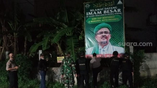 "Personel Polres Serang Kota, Kodim 0602 Serang, dan Pemkot Serang Kota menertibkan baliho/spanduk yang mengandung logo Front Pembela Islam (FPI), Rabu (30/12/2020) malam. (Suara.com/ Ahmad Haris)