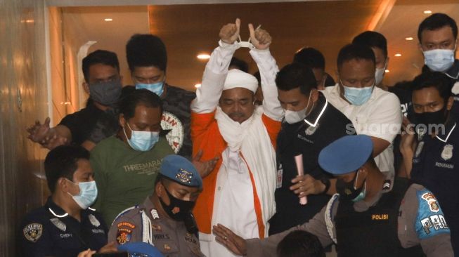 Imam besar FPI Habib Rizieq Shihab menggunakan baju tahanan usai diperiksa penyidik Polda Metro Jaya, Minggu (13/12/2020) dini hari. [Suara.com/Alfian Winanto]
