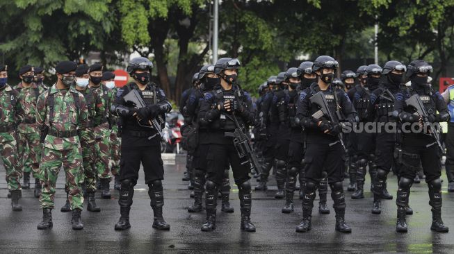 Personel gabungan TNI-Polri mengikuti Apel Pengamanan Malam Tahun Baru 2021 di Lapangan Promoter Ditlantas Polda Metro Jaya, Jakarta, Kamis (31/12/2020). [Suara.com/Angga Budhiyanto]