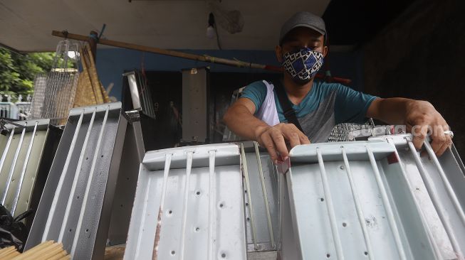 Pedagang alat panggang menata dagangannya di kawasan Pasar Minggu, Jakarta, Kamis (31/12/2020). [Suara.com/Angga Budhiyanto]