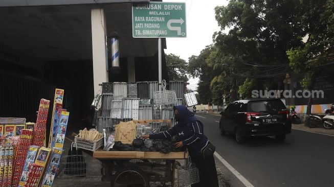 Pedagang alat panggang menata dagangannya di kawasan Pasar Minggu, Jakarta, Kamis (31/12/2020). [Suara.com/Angga Budhiyanto]