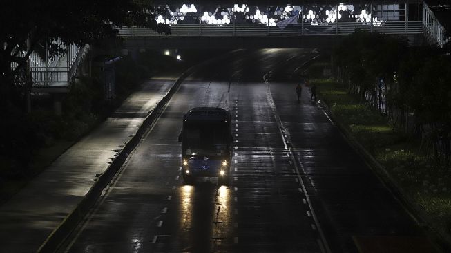 Bus Transjakarta melintas saat diberlakukannya Car Free Night (malam bebas kendaraan) dan Crowd Free Night (malam bebas keramaian) pada malam pergantian tahun di Jalan Sudirman, Jakarta, Kamis (31/12/2020). [Suara.com/Angga Budhiyanto]