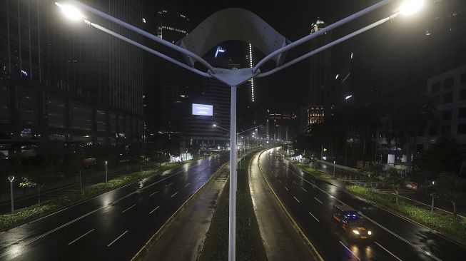 Petugas Satpol PP melaksanakan patroli  saat diberlakukannya Car Free Night (malam bebas kendaraan) dan Crowd Free Night (malam bebas keramaian) pada malam pergantian tahun di Jalan Sudirman, Jakarta, Kamis (31/12/2020). [Suara.com/Angga Budhiyanto]