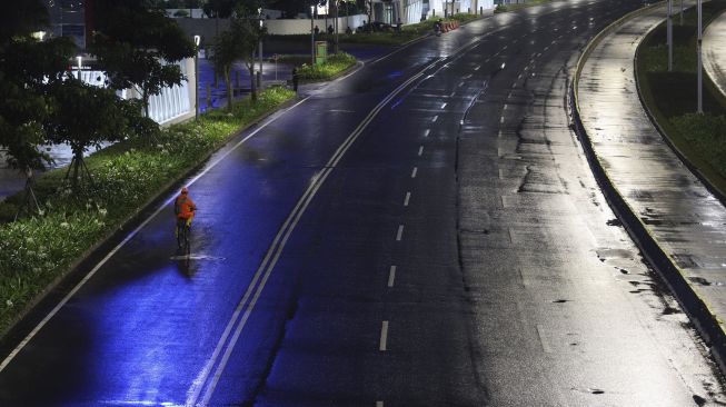 Warga bersepeda saat diberlakukannya Car Free Night (malam bebas kendaraan) dan Crowd Free Night (malam bebas keramaian) pada malam pergantian tahun di Jalan Sudirman, Jakarta, Kamis (31/12/2020). [Suara.com/Angga Budhiyanto]