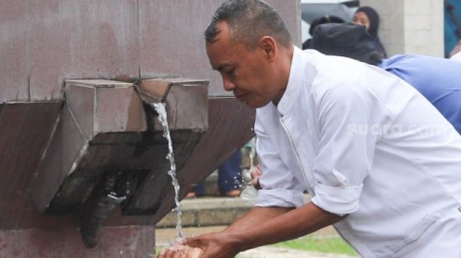Warga berwudhu untuk melaksanakan shalat jumat di Masjid Agung At-Tin, Taman Mini, Jakarta Timur, Jumat (1/1/2021). [Suara.com/Alfian Winanto]