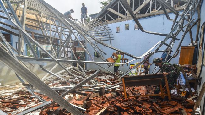 Sejumlah warga membantu menyelamatkan barang-barang pasca ambruknya atap ruang kelas SDN 1 Sukadana di Dusun Desa, Kabupaten Ciamis, Jawa Barat, Sabtu (2/1/2021). ANTARA FOTO/Adeng Bustomi