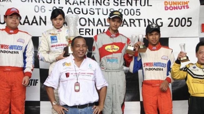 Alex Asmasoebrata berdiri di depan putrinya Alexandra saar penerimaan piala kejuaraan karting di Sentul 2005 [Instagram: alexandra.asma].