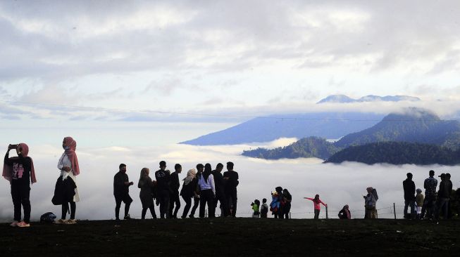 Pengunjung berada di tempat wisata Bukit Tirai Embun, Kerinci, Jambi, Minggu (3/1/2021). [ANTARA FOTO/Wahdi Septiawan]