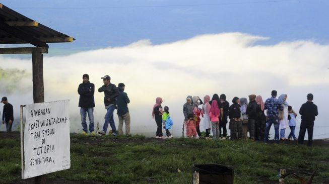 Pengunjung berada di tempat wisata Bukit Tirai Embun, Kerinci, Jambi, Minggu (3/1/2021). [ANTARA FOTO/Wahdi Septiawan]