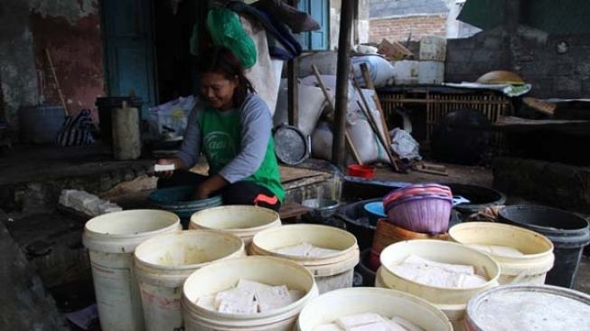 Salah satu perajin tahu di Desa Karanganom, Kecamatan Klaten Utara, Klaten, menata tahu hasil produksinya sebelum diolah menjadi tahu pong, Minggu (3/1/2021). (Solopos-Taufiq Sidik Prakoso)