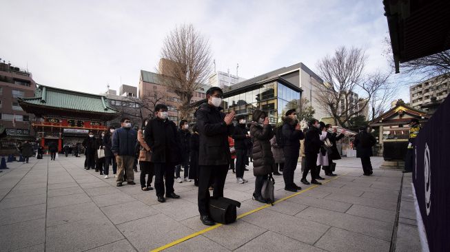 Orang-orang berdoa pada hari pertama kerja di tahun baru di kuil Kanda Myojin, Tokyo, Senin (4/1/2021). [Kazuhiro NOGI / AFP]