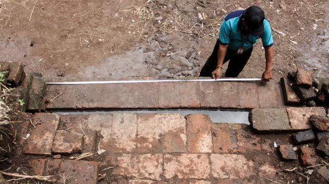 Petugas Balai Pelestarian Cagar Budaya (BPCB) Trowulan mengukur struktur bata kuno yang ditemukan warga di Dusun Blimbing, Desa Bulusari, Gempol, Pasuruan, Jawa Timur, Selasa (5/1/2021). ANTARA FOTO/Umarul Faruq
