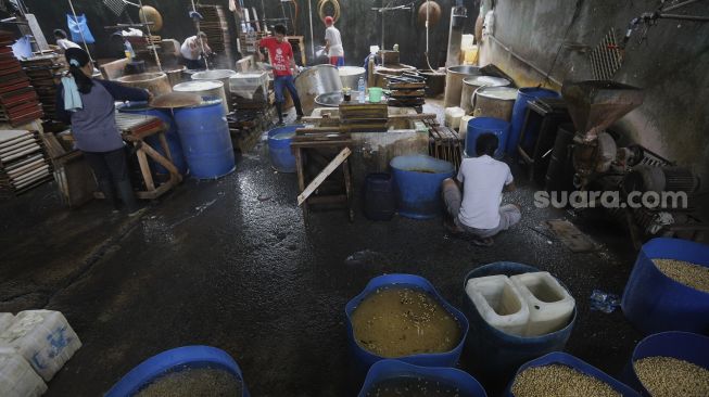 Pekerja memproduksi tahu di salah satu pabrik tahu di kawasan Duren Tiga, Jakarta, Selasa (5/1/2021). [Suara.com/Angga Budhiyanto]