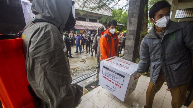 Petugas melakukan bongkar muat vaksin COVID-19 Sinovac saat tiba di Instalasi Gudang Farmasi dan Perlengkapan Kesehatan Kalsel, Banjarbaru, Kalimantan Selatan, Selasa (5/1/2021). Sebanyak 25.000 dosis vaksin COVID-19 Sinovac tahap pertama tiba di Banjarbaru, untuk selanjutnya disimpan di ruang pendingin atau cold room sebelum didistribusikan ke tingkat Kabupaten/Kota. ANTARA FOTO
