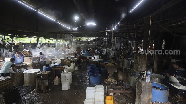 Pekerja memproduksi tahu di salah satu pabrik tahu di kawasan Duren Tiga, Jakarta, Selasa (5/1/2021). [Suara.com/Angga Budhiyanto]