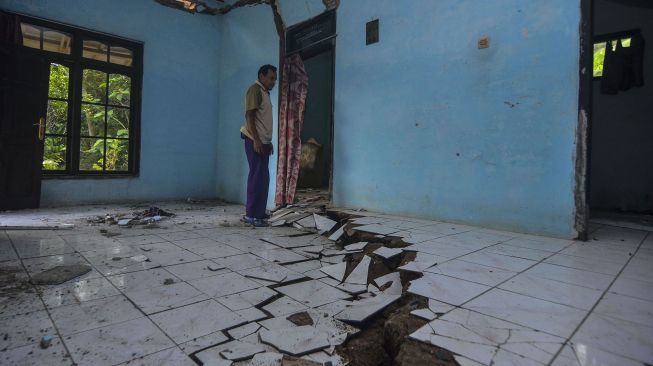 Warga menunjukkan kondisi rumah rusak akibat pergerakan tanah di Dusun Cilimus, Desa Indragiri, Kabupaten Ciamis, Jawa Barat, Rabu (6/1/2021).  ANTARA FOTO/Adeng Bustomi