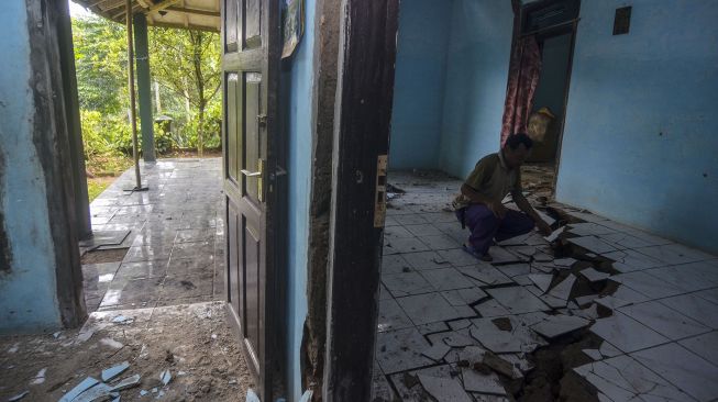 Warga menunjukkan kondisi rumah rusak akibat pergerakan tanah di Dusun Cilimus, Desa Indragiri, Kabupaten Ciamis, Jawa Barat, Rabu (6/1/2021).  ANTARA FOTO/Adeng Bustomi