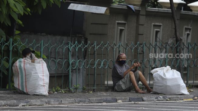 Penyandang Masalah Kesejahteraan Sosial (PMKS) beristirahat di kawasan Kuningan, Jakarta, Kamis (7/1/2021). [Suara.com/Angga Budhiyanto]