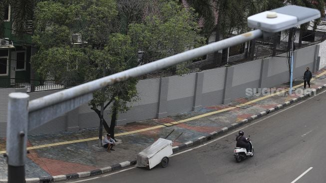 Penyandang Masalah Kesejahteraan Sosial (PMKS) beristirahat di kawasan Kuningan, Jakarta, Kamis (7/1/2021). [Suara.com/Angga Budhiyanto]