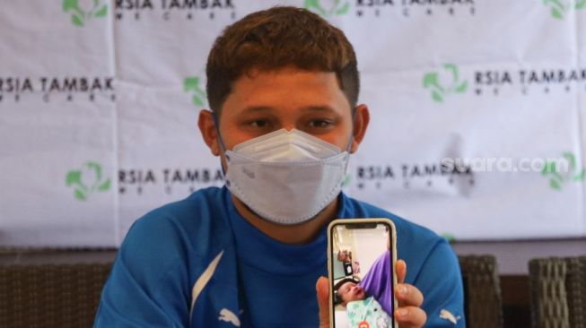 Pesepak bola Syamsir Alam menunjukkan foto putri pertamanya dengan Bunga Jelitha yang bernama Akleema Regalo Zulaikha saat konferensi pers di RSIA Tambak, Jakarta Pusat, Kamis (7/1/2021). [Suara.com/Alfian Winanto]