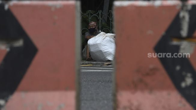 Penyandang Masalah Kesejahteraan Sosial (PMKS) beristirahat di kawasan Kuningan, Jakarta, Kamis (7/1/2021). [Suara.com/Angga Budhiyanto]