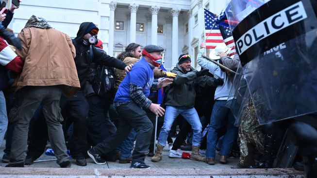 Pendukung Trump bentrok dengan polisi dan pasukan keamanan, saat mereka menyerbu Capitol AS di Washington, DC, pada 6 Januari 2021.  [AFP/Foto]