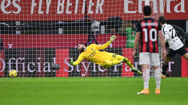 Penyerang Juventus Federico Chiesa (kanan) melepaskan tembakan untuk membuka skor melewati kiper AC Milan Gianluigi Donnarumma (Kiri) selama pertandingan sepak bola Serie A Italia AC Milan melawan Juventus di Stadion San Siro, Milan, Kamis (7/1) dini hari WIB. 
MIGUEL MEDINA / AFP