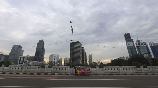 Penyandang Masalah Kesejahteraan Sosial (PMKS) membawa gerobak berjalan di kawasan Kuningan, Jakarta, Kamis (7/1/2021). [Suara.com/Angga Budhiyanto]