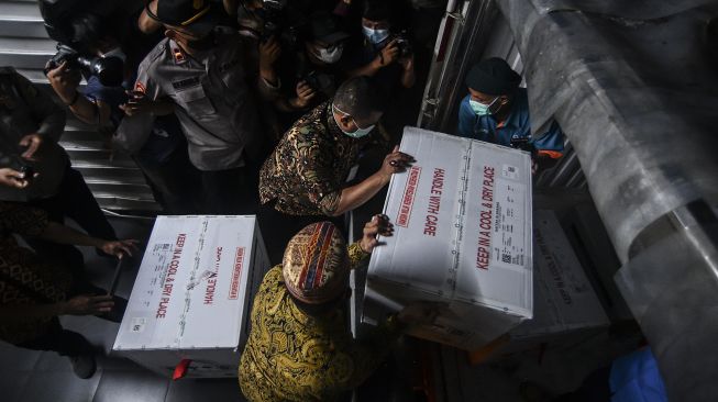 Petugas Dinas Kesehatan DKI Jakarta melakukan bongkar muat vaksin COVID-19 Sinovac setibanya di Dinas Kesehatan DKI Jakarta, Kamis (7/1/2021).  [ANTARA FOTO/Muhammad Adimaja]