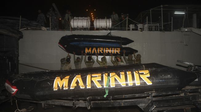 Prajurit Batalyon Intai Amfibi-1 (Taifib) Korps Marinir menaikkan perahu karet ke atas KRI Gilimanuk-531 di Dermaga Pelabuhan JICT 2, Jakarta, Sabtu (9/1/2021). [ANTARA FOTO/Akbar Nugroho Gumay]