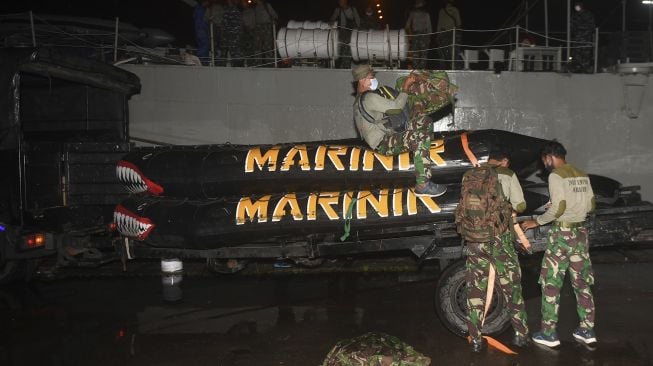 Prajurit Batalyon Intai Amfibi-1 (Taifib) Korps Marinir menaikkan perahu karet ke atas KRI Gilimanuk-531 di Dermaga Pelabuhan JICT 2, Jakarta, Sabtu (9/1/2021). [ANTARA FOTO/Akbar Nugroho Gumay]