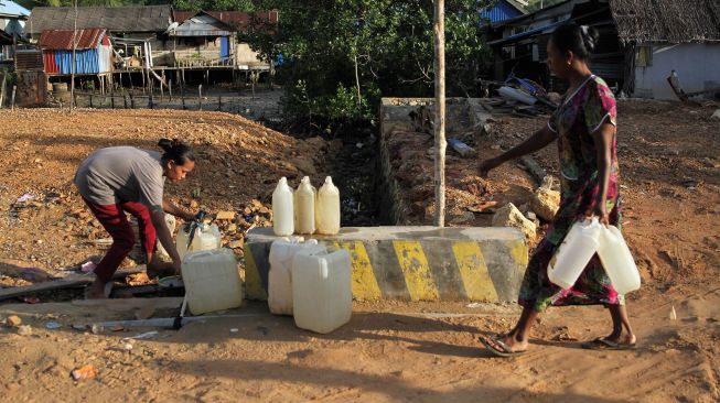 Warga suku Bajo mengisi air bersih ke dalam jirigen di Desa Leppe, Kecamatan Soropia, Kabupaten Konawe, Sulawesi Tenggara, Sabtu (9/1/2021).  ANTARA FOTO/Jojon
