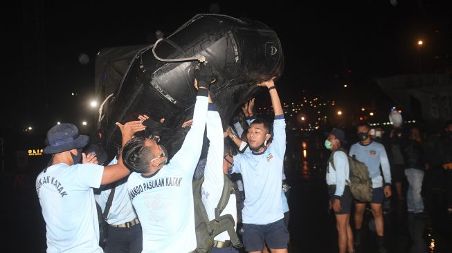 Prajurit Batalyon Intai Amfibi-1 (Taifib) Korps Marinir menaikkan perahu karet ke atas KRI Gilimanuk-531 di Dermaga Pelabuhan JICT 2, Jakarta, Sabtu (9/1/2021). [ANTARA FOTO/Akbar Nugroho Gumay]