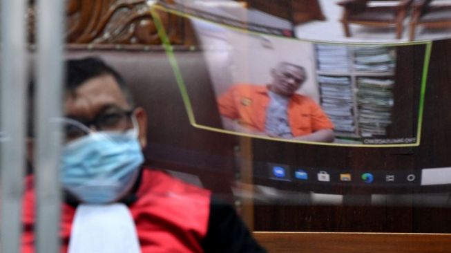 Refleksi kaca dari layar monitor aktor Irwan Susetyo alias Tio Pakusadewo (kanan) saat menjalani sidang tuntutan kasus narkoba di Pengadilan Negeri Jakarta Selatan, Jakarta, Selasa (5/1/2021). Dalam sidang yang digelar secara virtual tersebut Tio Pakusadewo dituntut pidana 2 tahun penjara dikurangi masa tahanan sementara. ANTARA FOTO/Sigid Kurniawan]
