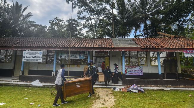 Petugas menyelamatkan barang-barang sekolah pasca ambruknya atap ruang kelas SDN 2 Janggala di Dusun Sukalilah, Kecamatan Cidolong, Kabupaten Ciamis, Jawa Barat, Senin (11/1/2021). [ANTARA FOTO/Adeng Bustomi]