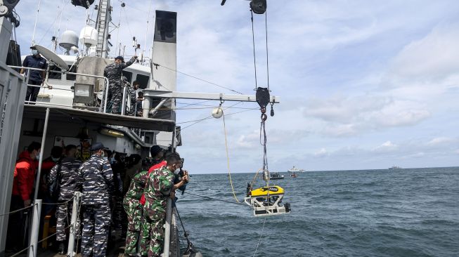 Sejumlah prajurit TNI AL pengawak KRI Rigel-933 mengamati robot bawah laut atau 'Remotely Operated Vehicle (ROV)' yang diturunkan di perairan Kepulauan Seribu, Jakarta, Senin (11/1/2021). [ANTARA FOTO/M Risyal Hidayat]
