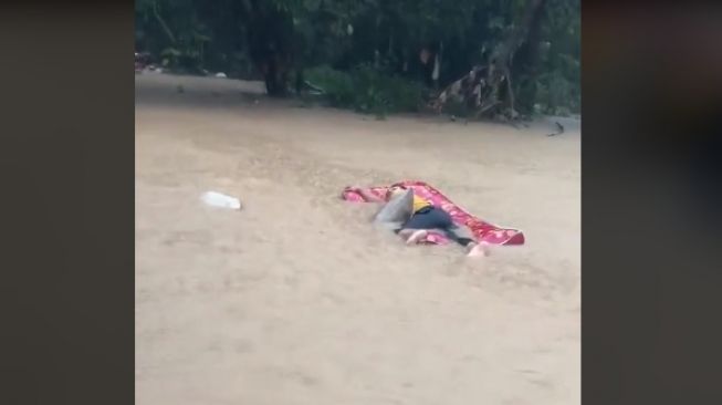 Tetap Rebahan Meski Hanyut, Tingkah Pemuda saat Banjir Bikin Geleng Kepala