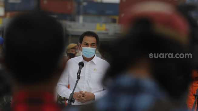 Wakil Ketua DPR Aziz Syamsuddin memberikan keterangan kepada awak media saat meninjau penanganan evakuasi pesawat Sriwijaya Air SJ 182 di Dermaga JICT, Tanjung Priok, Jakarta, Senin (11/1/2021). [Suara.com/Angga Budhiyanto]