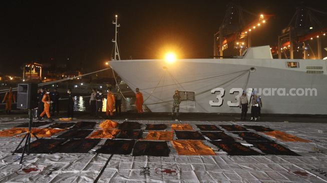 Petugas Basarnas menata kantong jenazah berisi bagian tubuh korban pesawat Sriwijaya Air SJ 182 rute Jakarta - Pontianak yang hilang kontak di perairan Kepulauan Seribu, di Dermaga JICT, Tanjung Priok, Jakarta, Senin (11/1/2021). [Suara.com/Angga Budhiyanto]