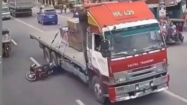 Pemotor nyaris saja terlindas ban truk ketika melintas di jalan (Instagram)