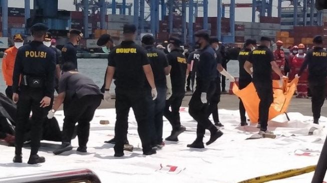 Tim Disaster Victim Identification (DVI) Polri membopong kantong jenazah berisi bagian tubuh diduga korban kecelakaan pesawat Sriwijaya Air dari KN SAR Basudewa di dermaga Jakarta International Container Terminal (JICT) Tanjung Priok Jakarta Utara, Senin (11/1/2021). [ANTARA/Devi Nindy]